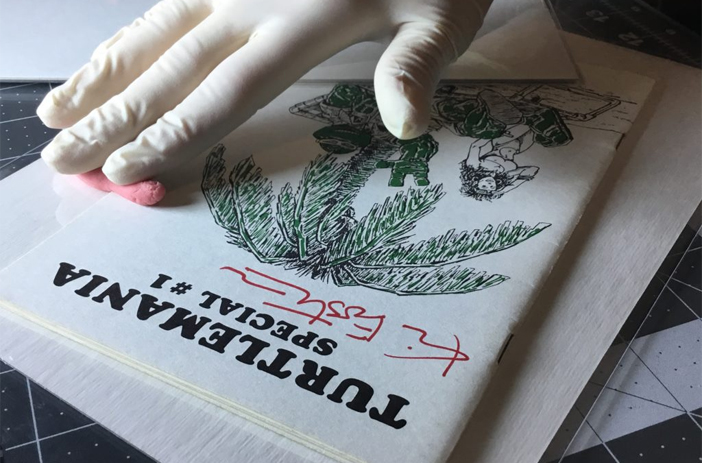 Person pressing comic book at home