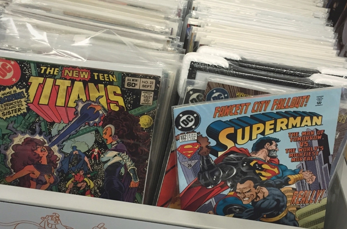 Person sorting through stack of comic books