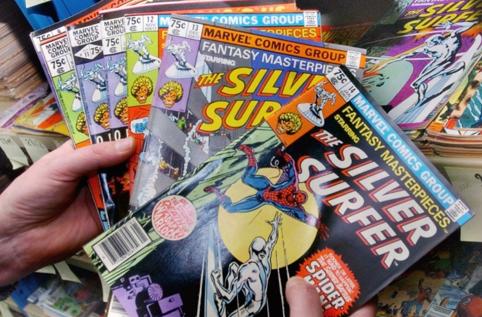 Person sorting through stack of comic books