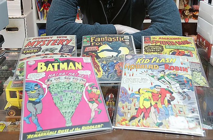 Person weighing comic book selling options