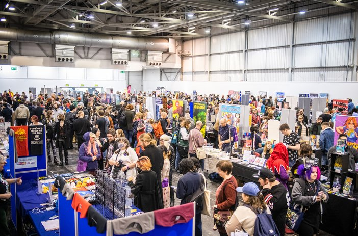 Comic book collectors browsing at convention tables