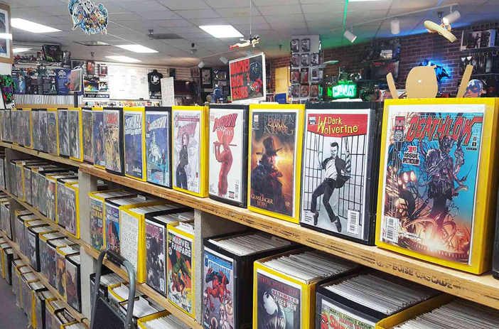 Person browsing comics at a convention table