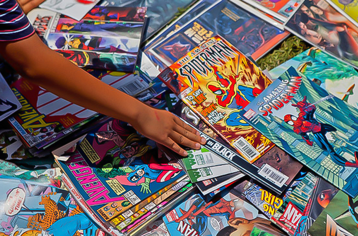 Stack of unsorted comic books being reviewed
