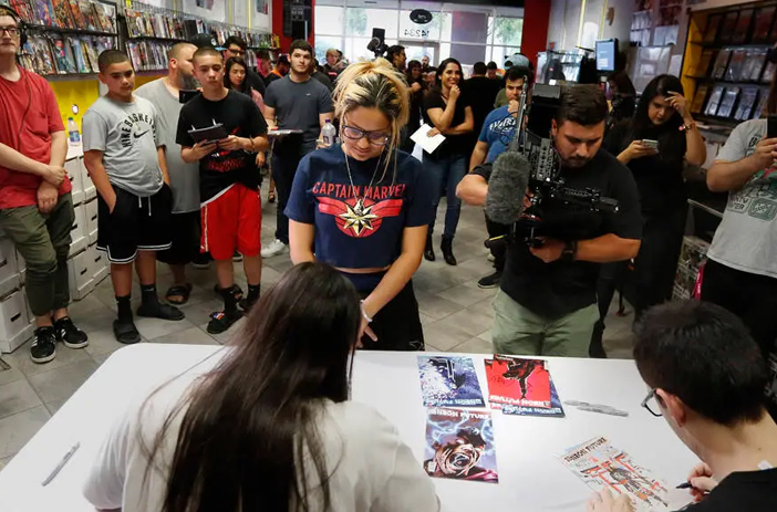 Person watching comic book being signed