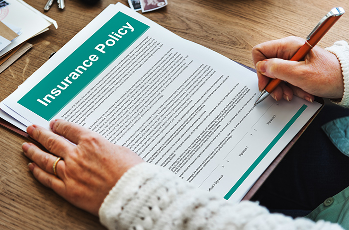 Person reviewing insurance policy documents carefully